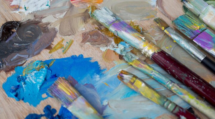 Painting tools and brushes with vibrant paint for creative artwork showing hobbies in resume.