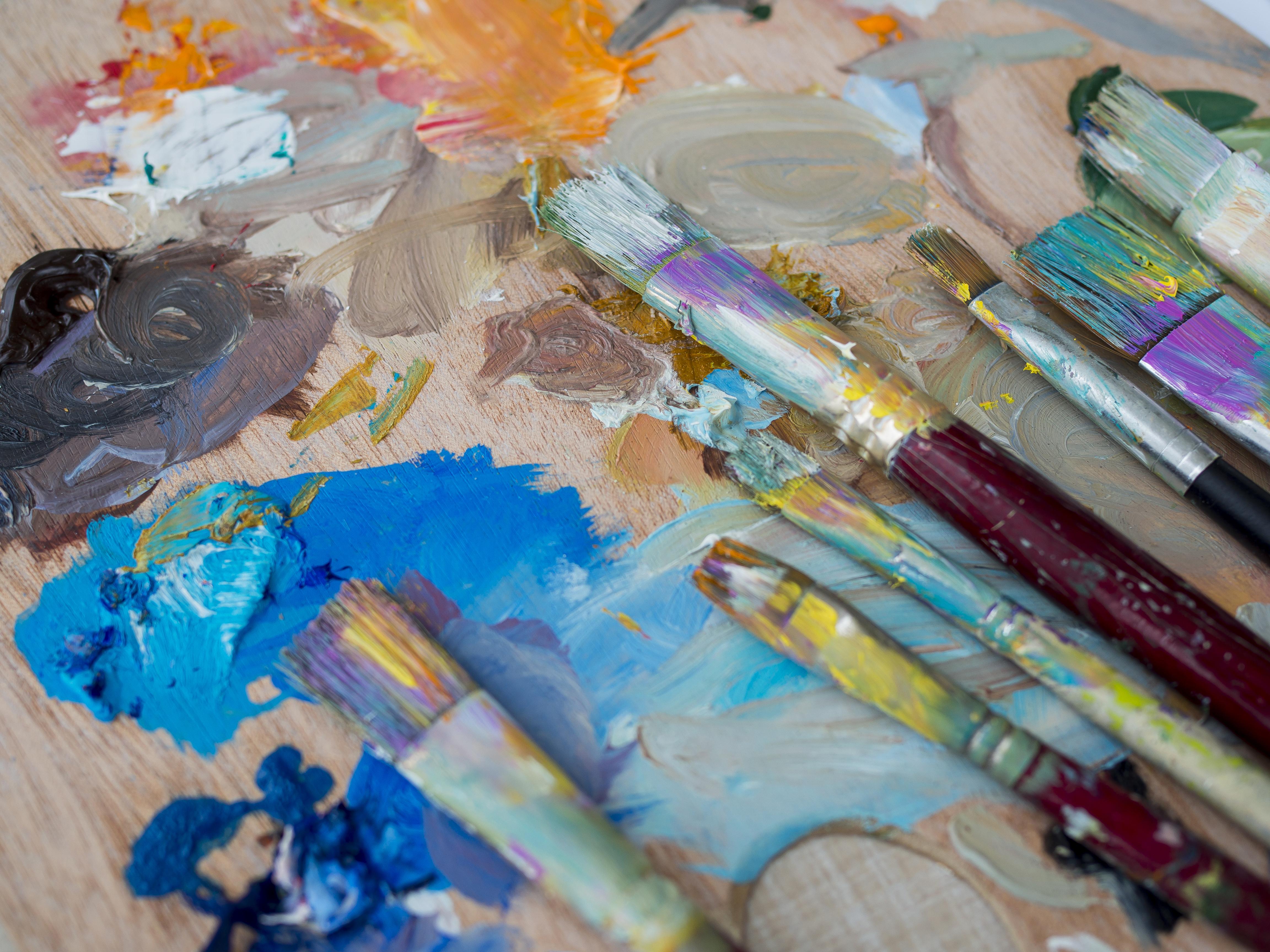 Painting tools and brushes with vibrant paint for creative artwork showing hobbies in resume.